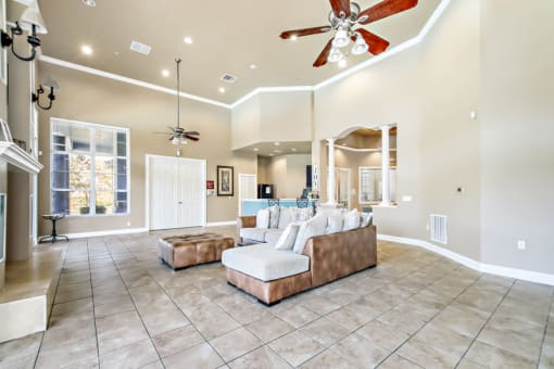 a large living room with tile flooring and a ceiling fan