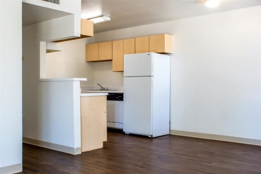 Kitchen with White Appliances, Blonde Wood Cabinets and White Counters