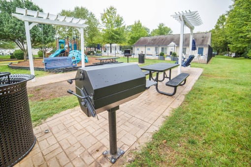 Outdoor gill and seating area. Playground in background.
