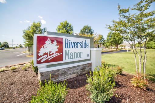 Community Entrance Sign with Shrubs and trees in background