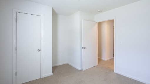 a bedroom with white walls and carpet