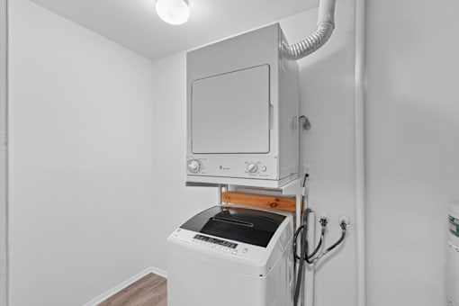 A white washing machine is installed in a small room.