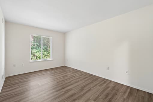 Empty room with wooden floor and a window.