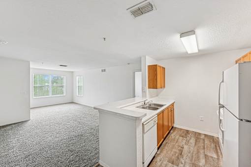 A kitchen with white appliances and wooden cabinets.