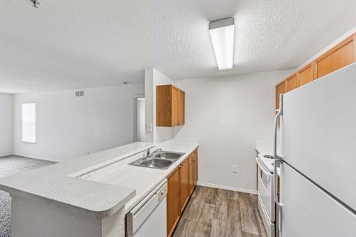 A kitchen with white countertops and wooden cabinets.