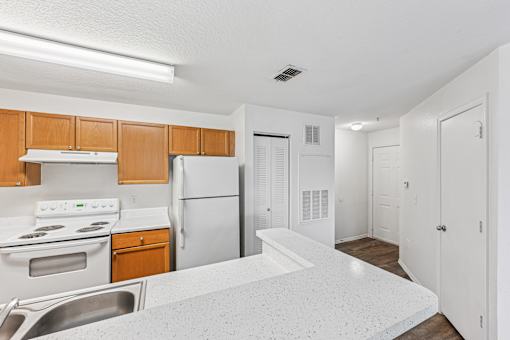 A kitchen with white appliances and wooden cabinets.