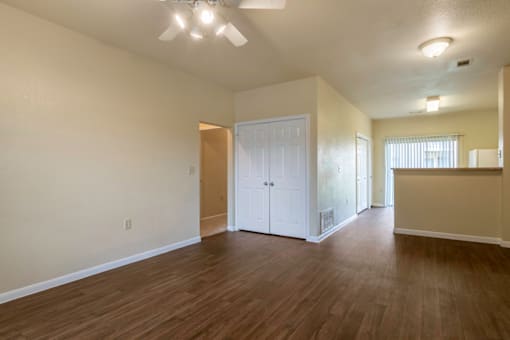 the living room and dining room of an empty home with wood flooring
