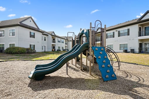 a playground with a slide at an apartment complex