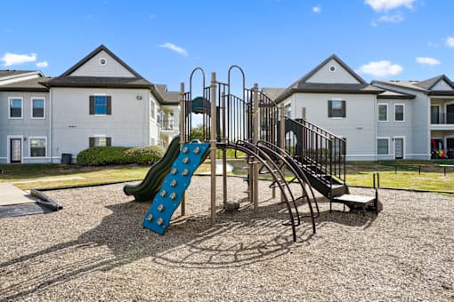 a playground with a slide in front of apartments