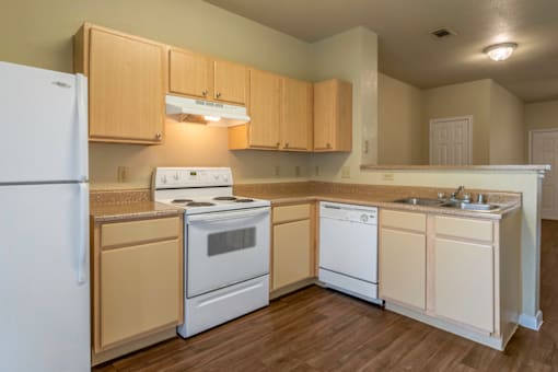 an empty kitchen with white appliances and wooden cabinets