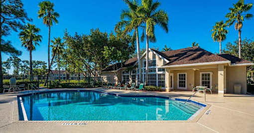 Swimming Pool and Sun Deck with Lounge Chairs with Trees and Building Exteriors in the Background