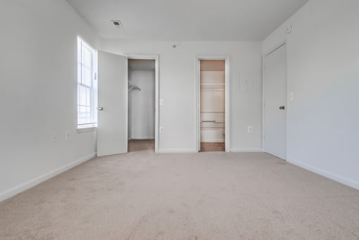 a bedroom with white walls and carpet
