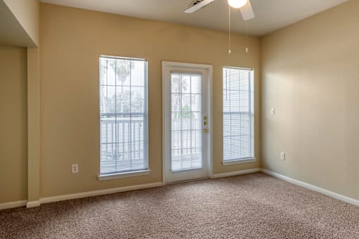 a bedroom with three windows and a ceiling fan