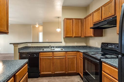 a kitchen with black appliances and wood cabinets