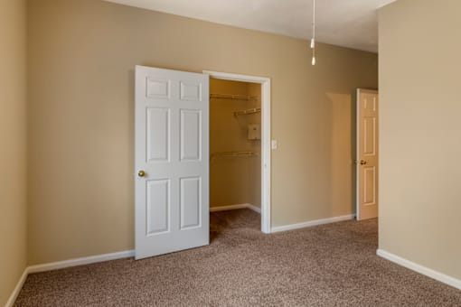a bedroom with a closet and a door that is open