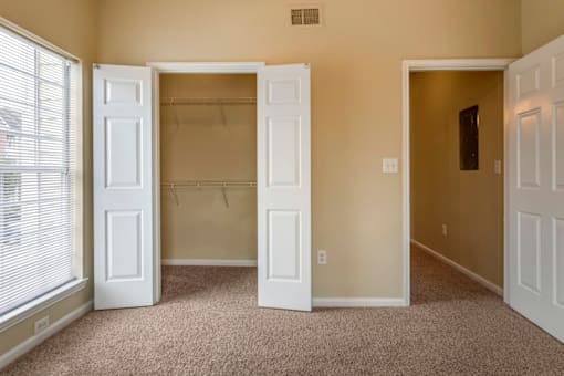 a bedroom with two closets and a window