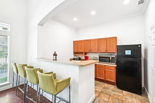 a kitchen with white walls and wood cabinets