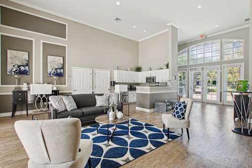 A living room with a couch, chairs, and a rug.