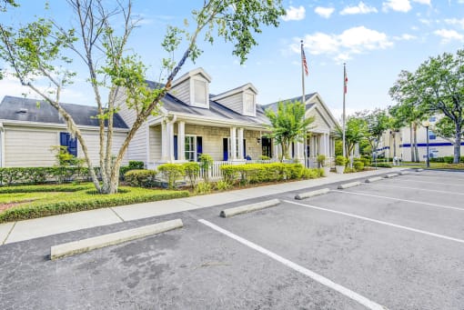Clubhouse exterior entrance and parking lot with flag poles and native landscape