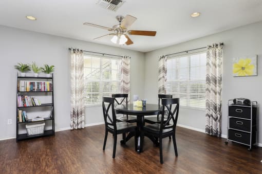 Clubhouse interior with hardwood style flooring, table, and chairs in the background.