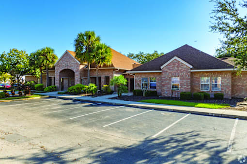 A parking lot in front of a building with a clear blue sky.