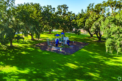 A playground with a blue slide and a blue and white swing set.