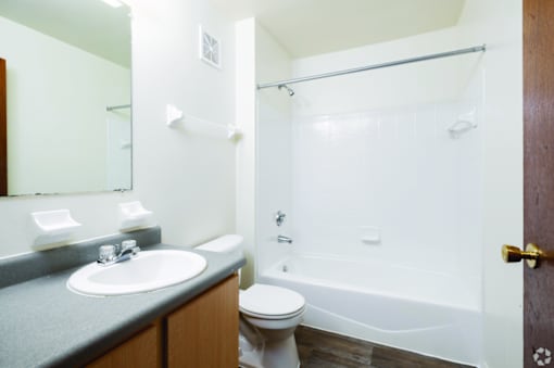 A white toilet sits next to a white sink in a bathroom.