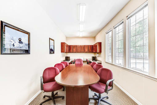 Business Center with Conference Table Maroon Chairs and Computers and Wood Cabinets