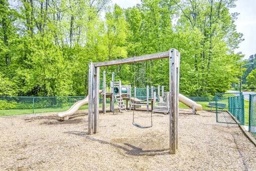 Fenced in Wooden Playground with Swing Set on Mulch