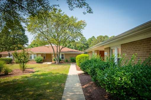 a walkway between two buildings at the whispering winds apartments in pearland, tx