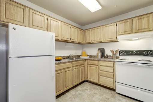 a kitchen with a white refrigerator freezer next to a stove top oven