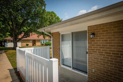 a balcony with a white fence in front of a brick building