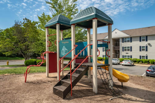 Playground with wood chips in court yard between buildings.