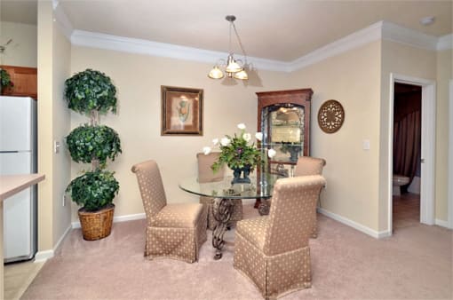 Dining area adjacent to kitchen and living room. A circular table with four surrounding chairs is in the middle of the room.