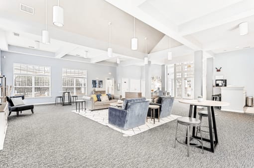 Spacious Open Clubhouse Seating Area with Couches Chairs Tables and Coffee bar and a Leasing Desk