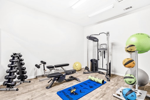 Bright Fitness Center with Exercise Equipment , free weights, and yoga mat.