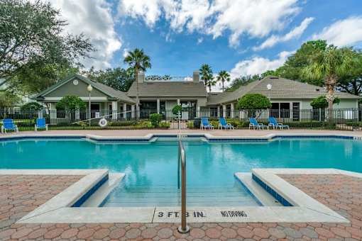 Swimming pool lounge seating, sun deck, with clubhouse in the background