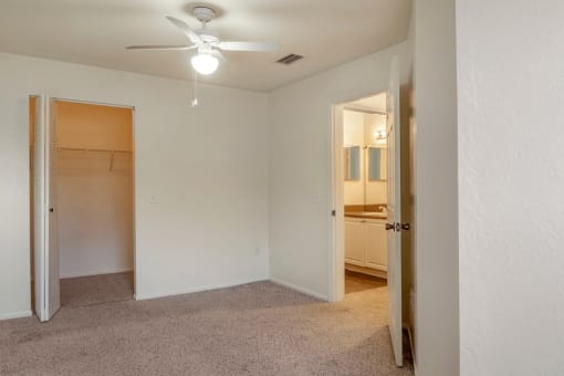 Spacious bedroom with carpet flooring, multi speed ceiling fan, and large walk-in closet