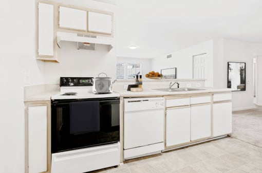 Virtually staged kitchen with tile floors, white appliances, and wood cabinets.