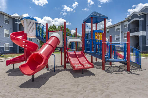Outdoor playground equipped with two slides, monkey bars, and spiral latter