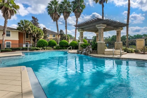 Swimming pool with lounge seating and shaded poolside spa surrounded by native landscaping