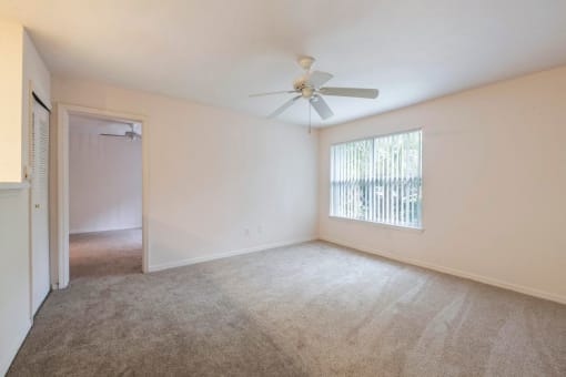 Carpeted Living Room with Ceiling Fan and  Large Window with Vertical Blinds