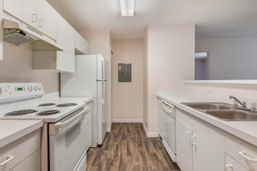 Kitchen with White Cabinets and Appliances with White Counters Double Sink and Breakfast BAr