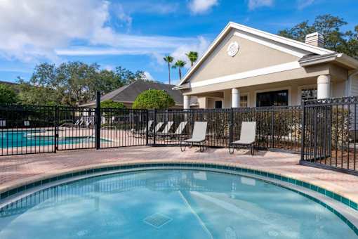 Fenced in Wading Pool with Lounge Chairs and Leasing Office Exterior in the Background