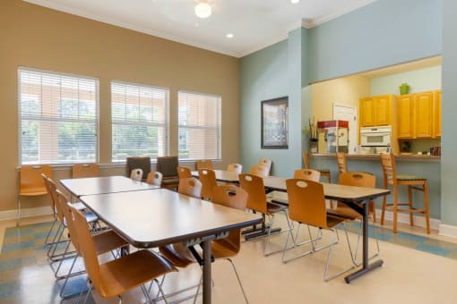 Resident Event and Recreation Room in Clubhouse with tables and chairs, and view of kitchen