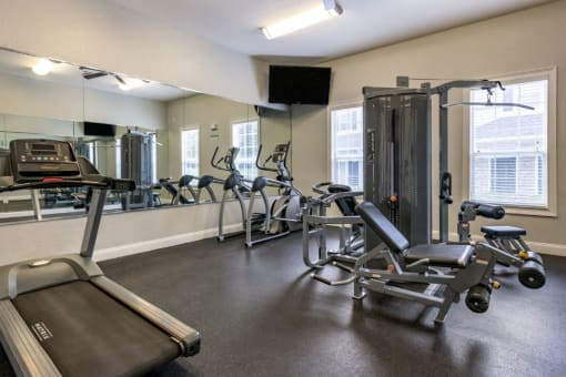 Fitness center with strength and conditioning equipment, cardio equipment, and large mirrors