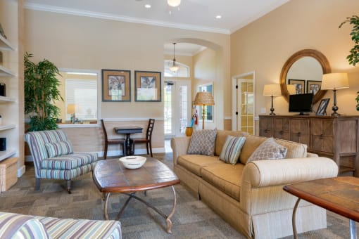 Clubhouse Interior with couch, coffee table, leasing office in the back ground
