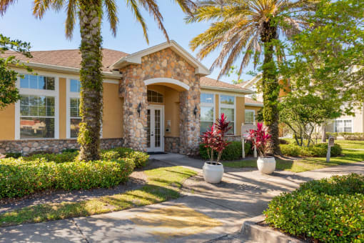 Club House Entrance with long sidewalk surrounded by palm trees