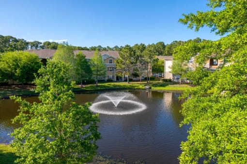 Lake view with fountain in the middle and exterior buildings in the back ground