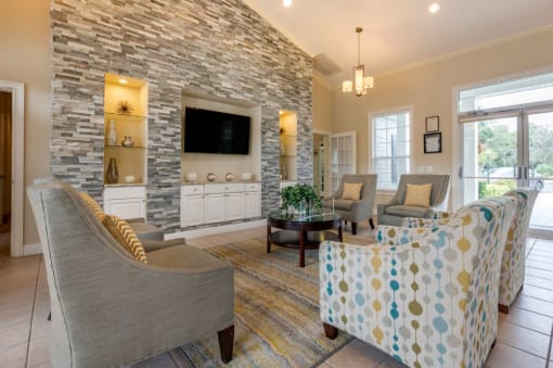 Clubhouse lounge with chairs, coffee table, rug, television, and built-in book shelves